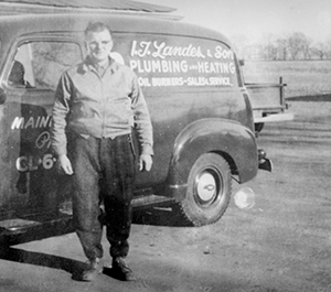 Older photo of an IT Landes plumbing and heating truck and employee